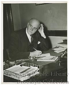 [John F. Collins at desk]