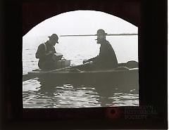 [Two men in a rowboat]
